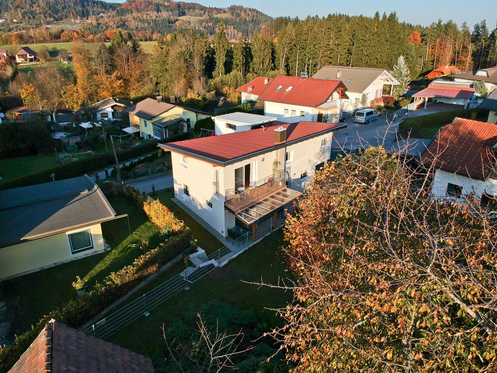 Ferienwohnung Greiler – Drohnenfoto einer Immobilie in Villach Land; herbstliche Stimmung mit seitlichen Blick auf die Immobilie, freundliches, ländliches Ambiente.